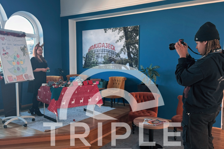 Sabrina am Sockenstand; Fotograf dokumentiert den Firmenweihnachtsmarkt bei Triple S